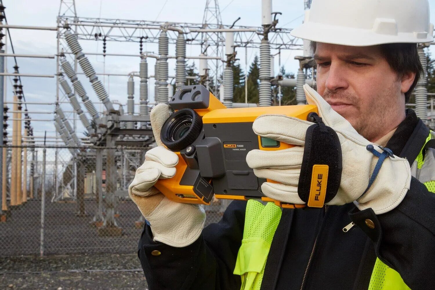 A technician at a substation holding the Fluke TiX501 with its lens rotated